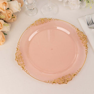 Elegant pink plate with gold ornate trim on a table setting.
