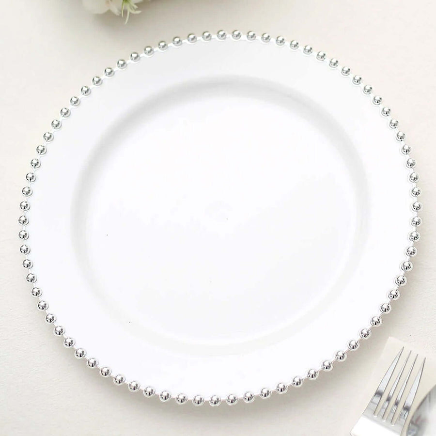 White plate with silver bead trim on a plain background