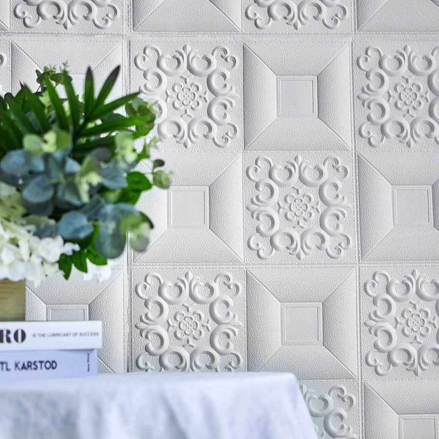 Textured white wall panel with decorative patterns and a plant in the foreground.