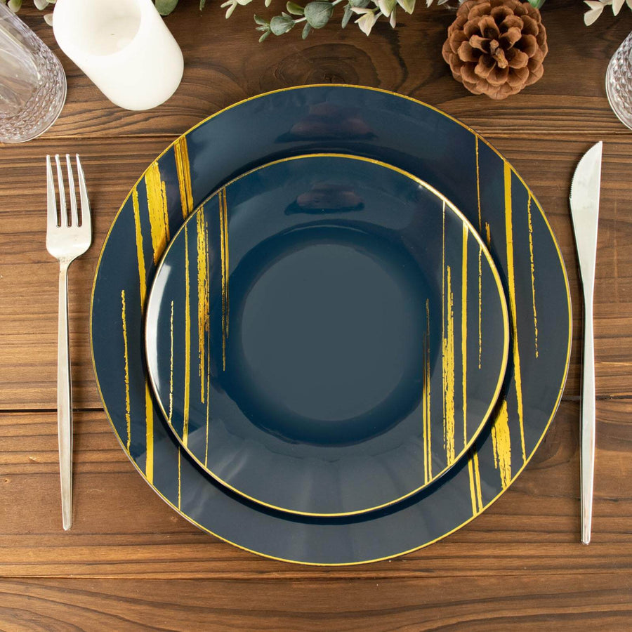 Elegant navy dinner plate set with gold accents on a rustic wooden table.