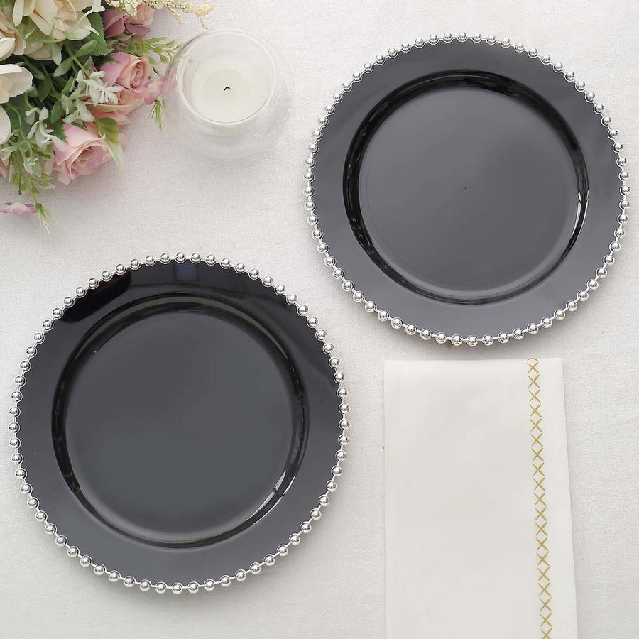 Black decorative plates with silver beaded edges on a light background.