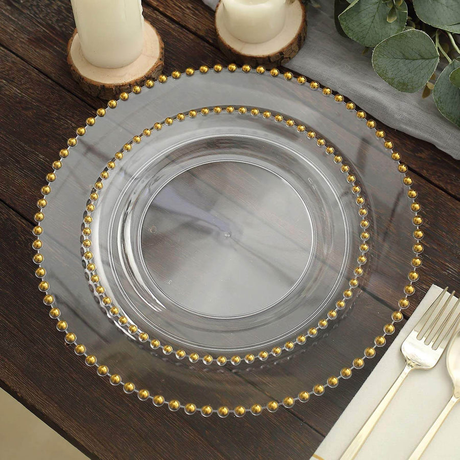Clear decorative charger plate with gold bead accents on a rustic table setting.