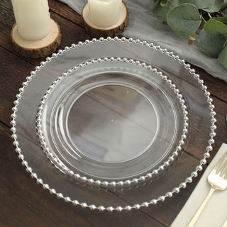 Clear decorative plates with beaded edges on a rustic wooden table.