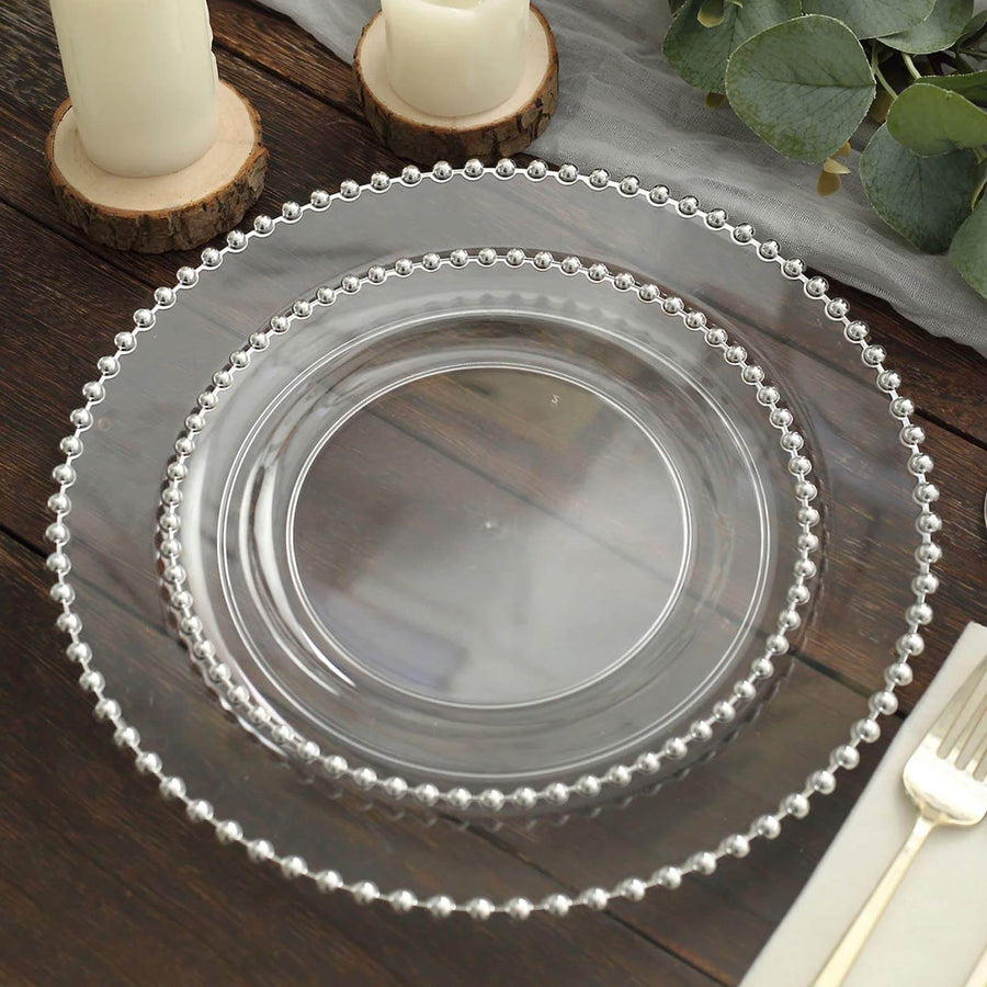 Clear decorative plates with beaded edges on a rustic wooden table.