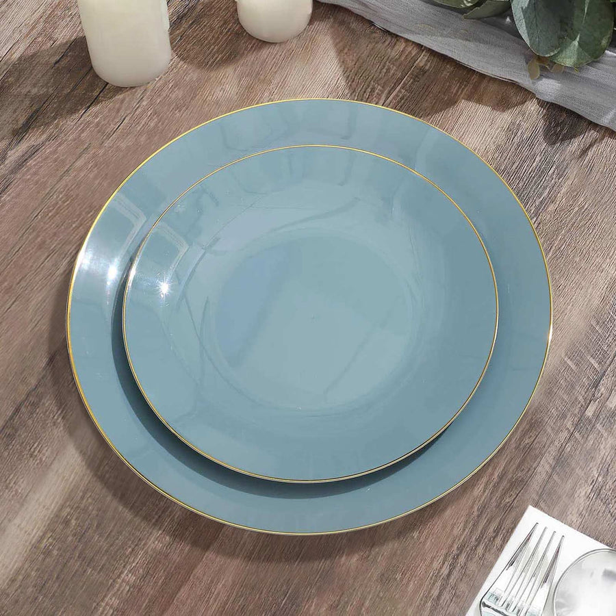 Elegant blue plates with gold trim on a wooden table setting.