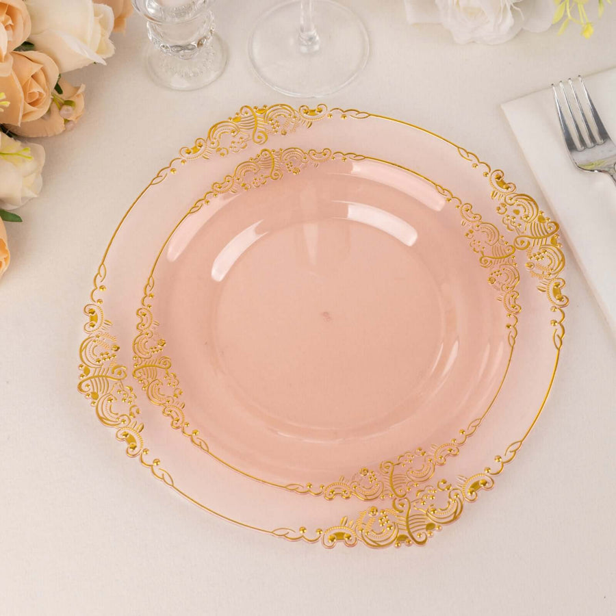 Elegant pink plate with gold embellishments on a table setting.