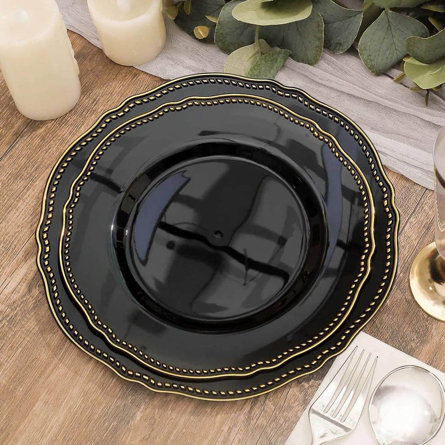 Black decorative plate with gold detailing on a wooden table.