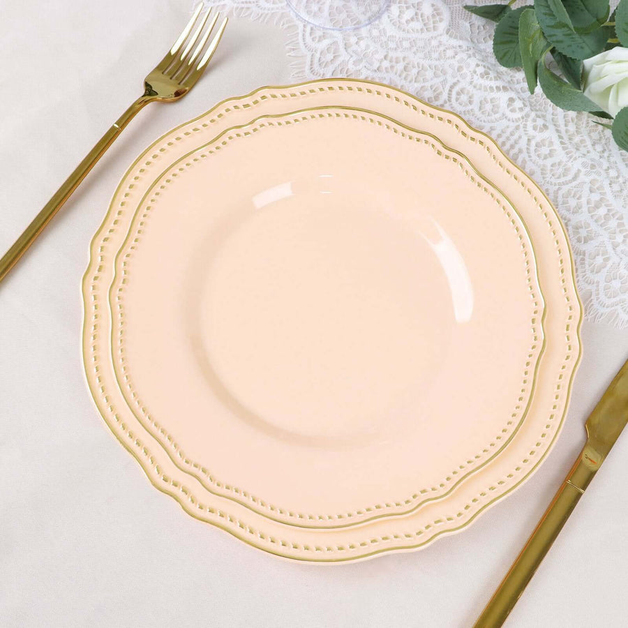 Peach decorative plate with gold trim, elegantly set on a lace tablecloth.