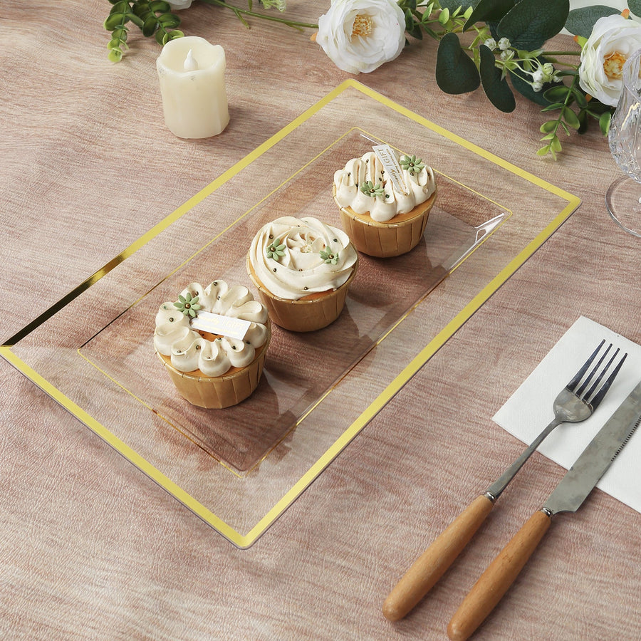 Three decorated cupcakes on a clear serving platter with elegant design.