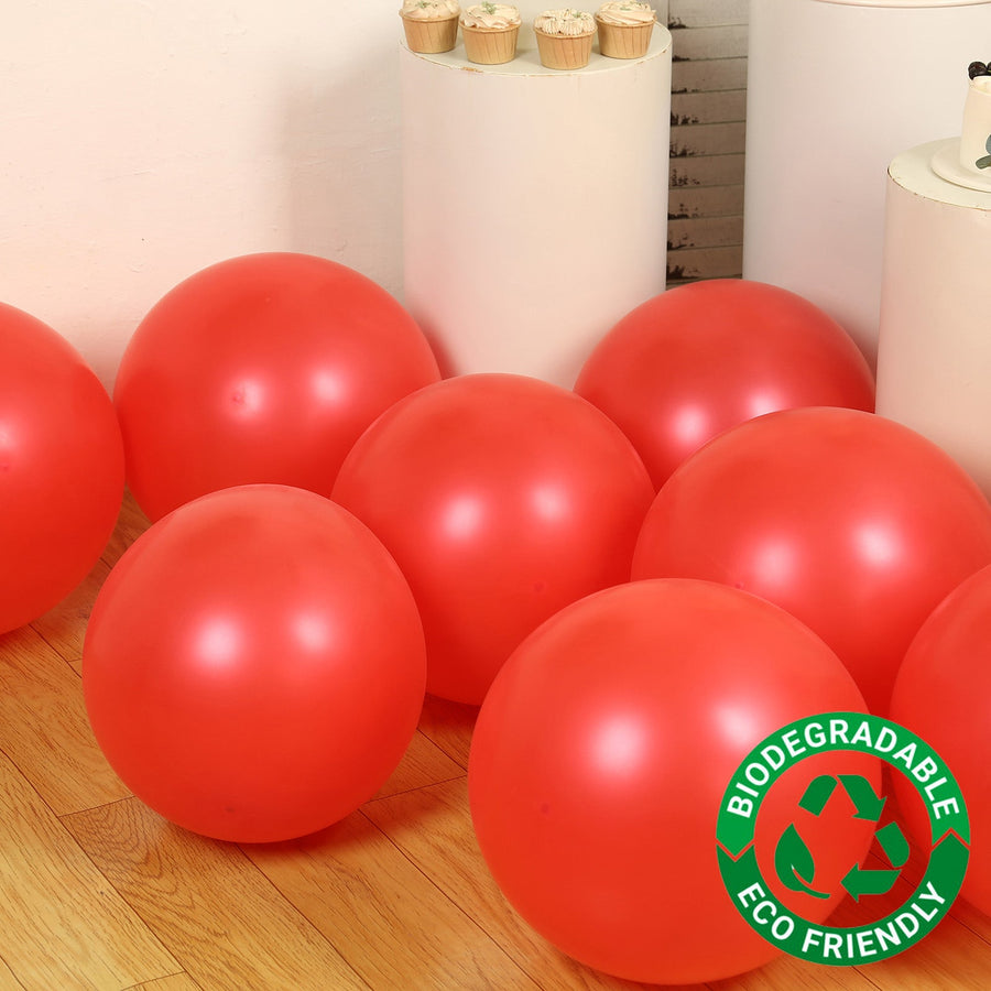 Biodegradable eco-friendly red balloons on a wooden floor.
