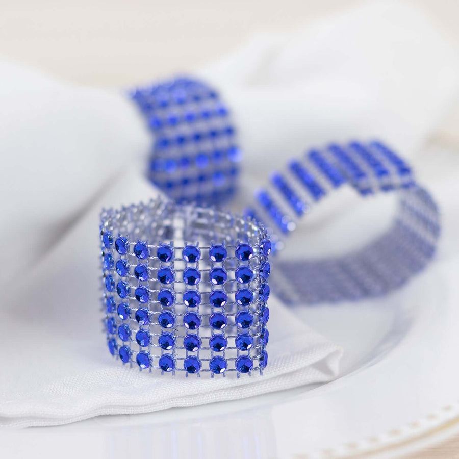 Blue crystal napkin rings elegantly displayed on a white table setting.