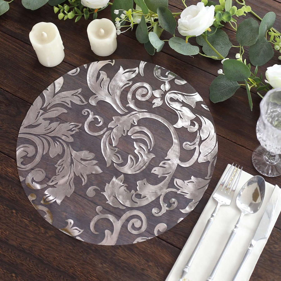 Elegant silver floral design placemat on a rustic wooden table.