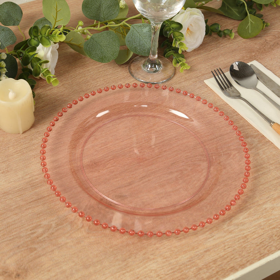 Clear pink charger plate with decorative beads on the edge.