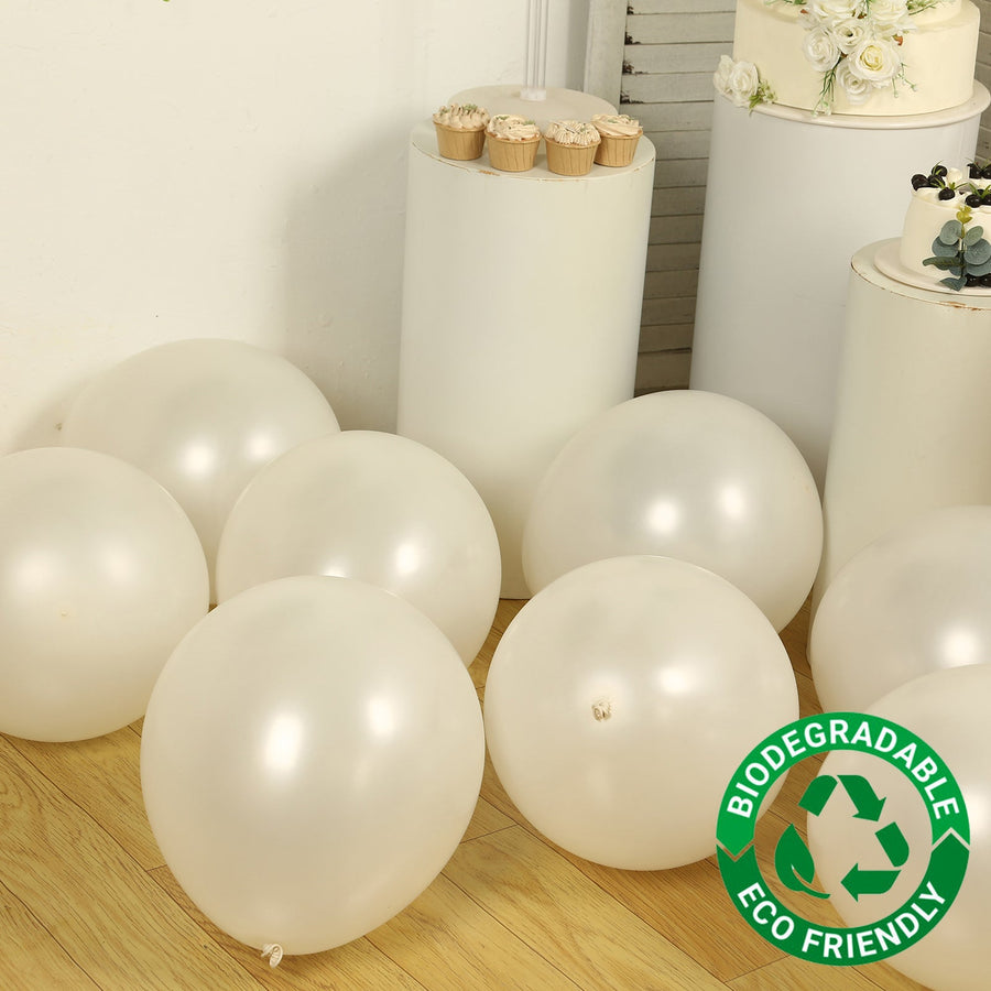 Biodegradable white balloons on a wooden floor with eco-friendly branding.