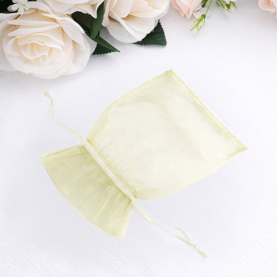Sheer yellow organza gift bag on white background