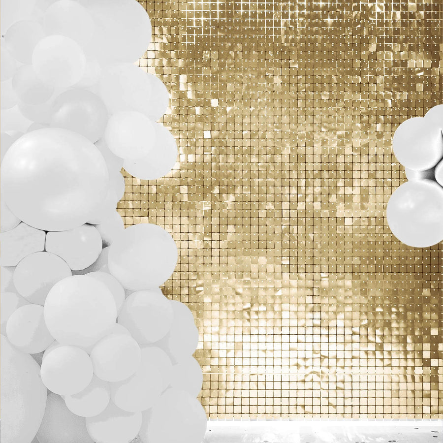 White balloons against a gold mirrored backdrop for event decoration.