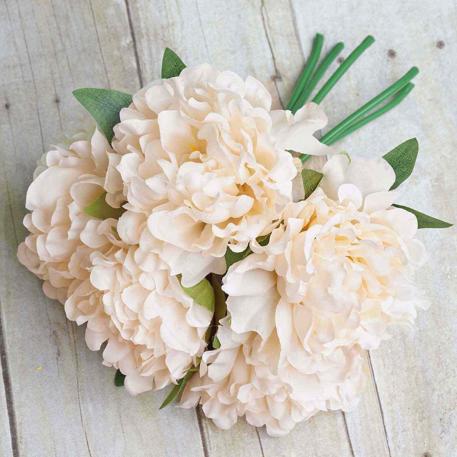 Peach artificial peony flower bouquet on wooden background.