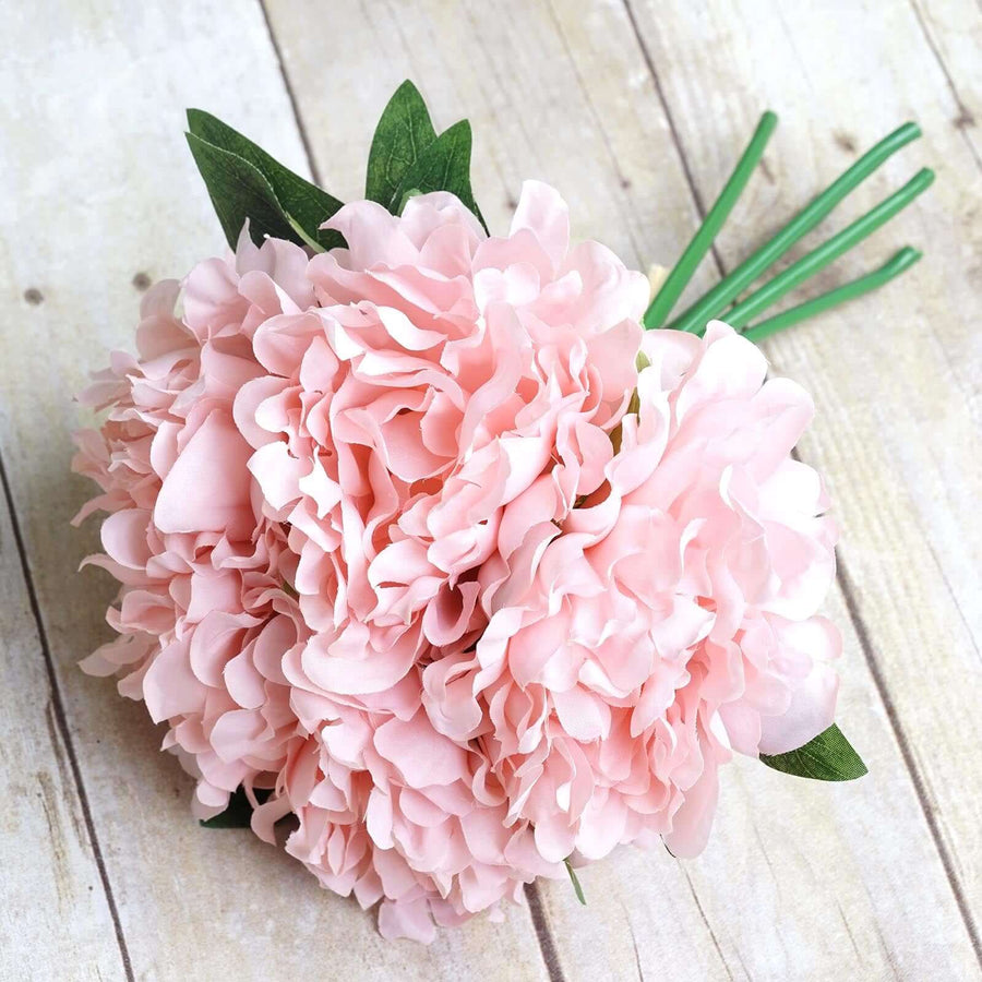 Pink peony bouquet on a rustic wooden surface.