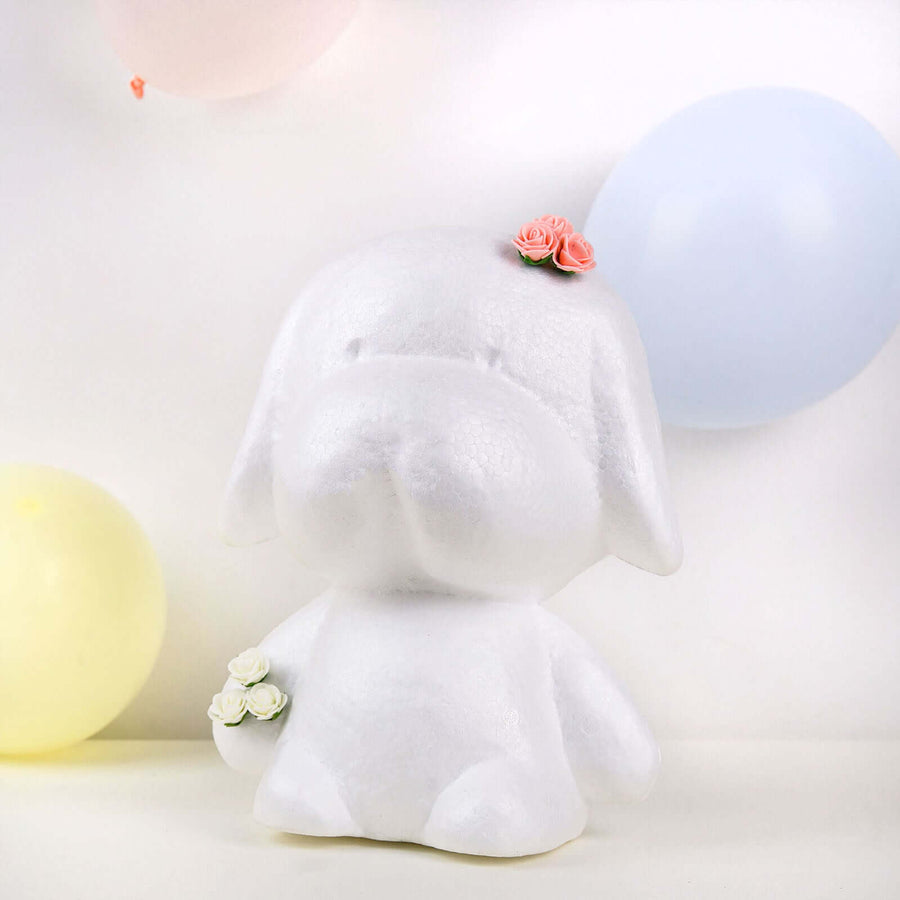 Ceramic dog figurine with flowers and balloons in the background.
