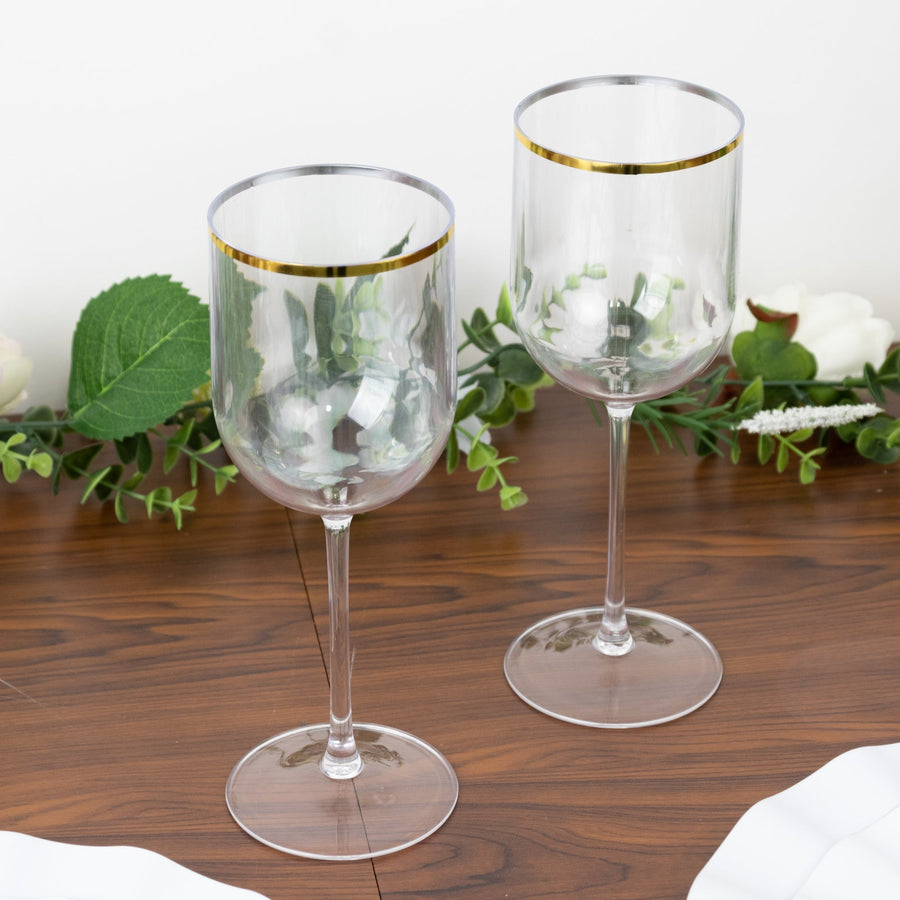 Elegant transparent wine glasses with gold rim on a wooden table.