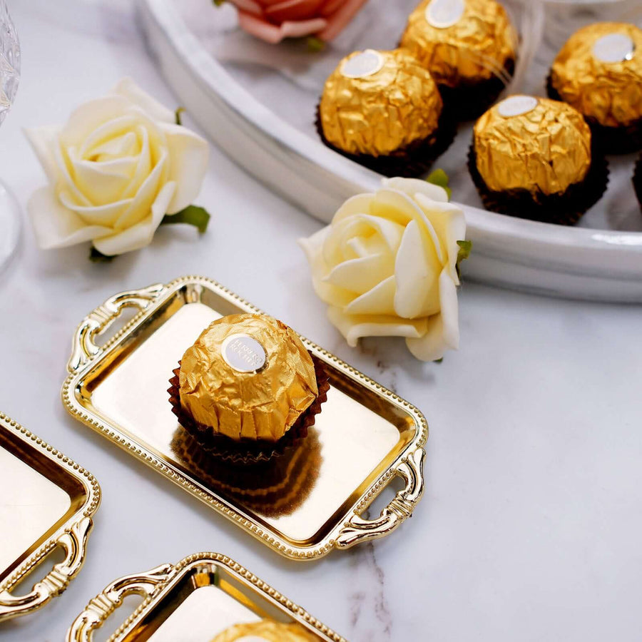 Golden chocolate truffle on a decorative tray with white roses.