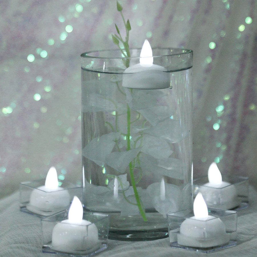 Floating candles in a glass vase with decorative elements.