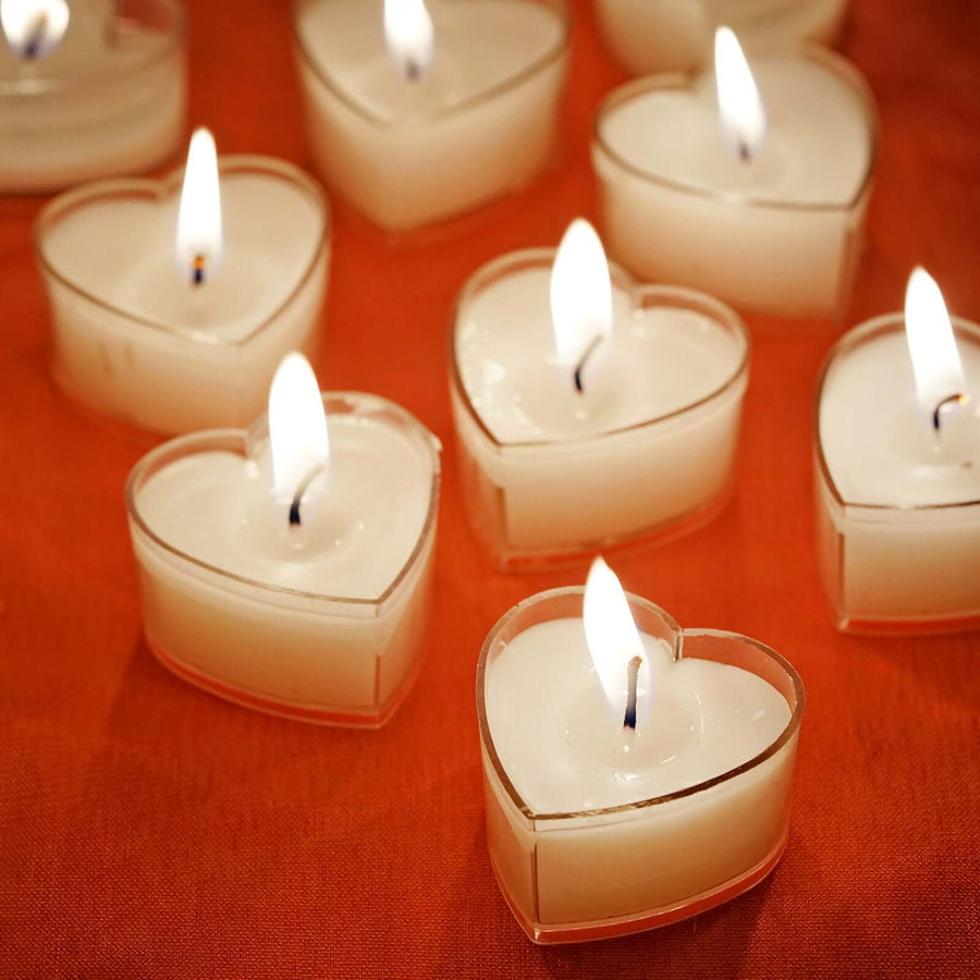 Heart-shaped tealight candles with flames glowing.