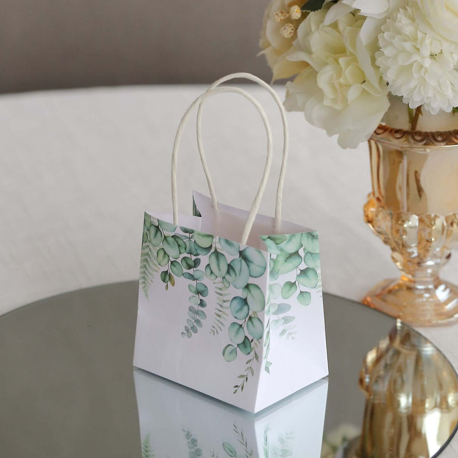 Decorative gift bag with green foliage design on a reflective surface.