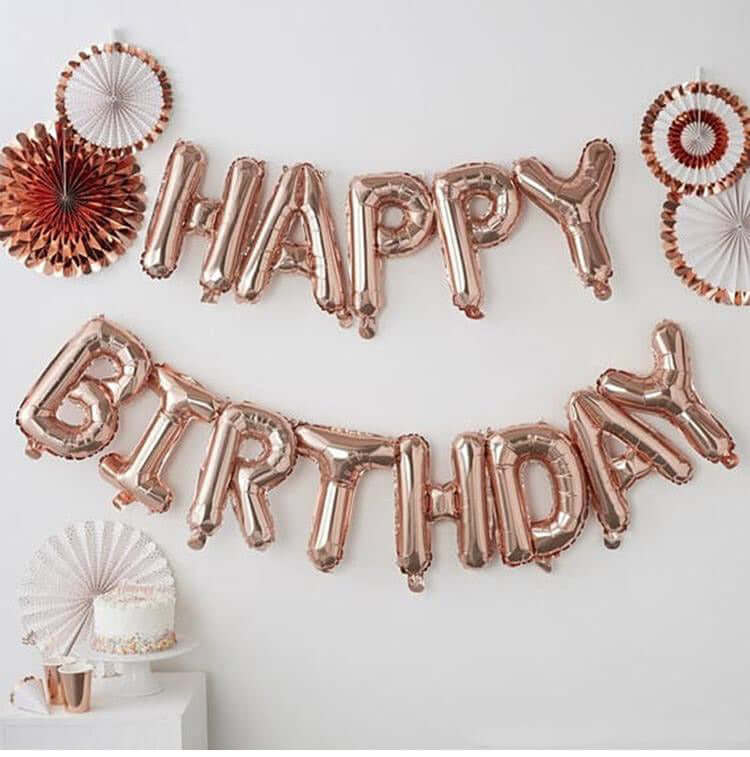 Rose gold "Happy Birthday" balloon banner with decorative fans.