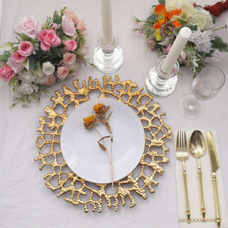 Elegant table setting with gold plate, cutlery, and floral arrangements.