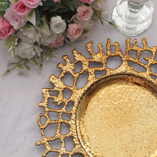 Gold decorative tray with intricate design against floral arrangement.