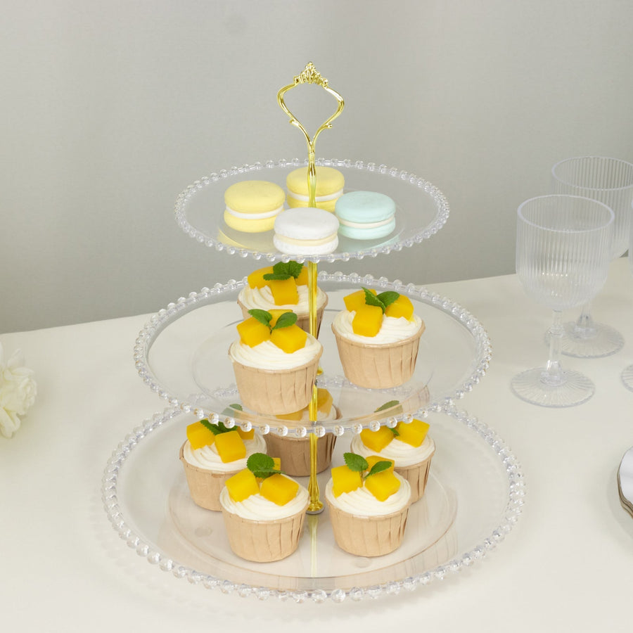 Three-tiered dessert stand with cupcakes and macarons.
