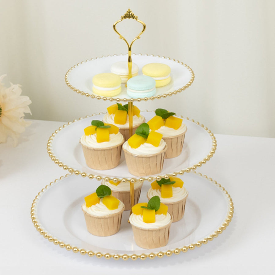 Three-tiered dessert stand with cupcakes and macarons.