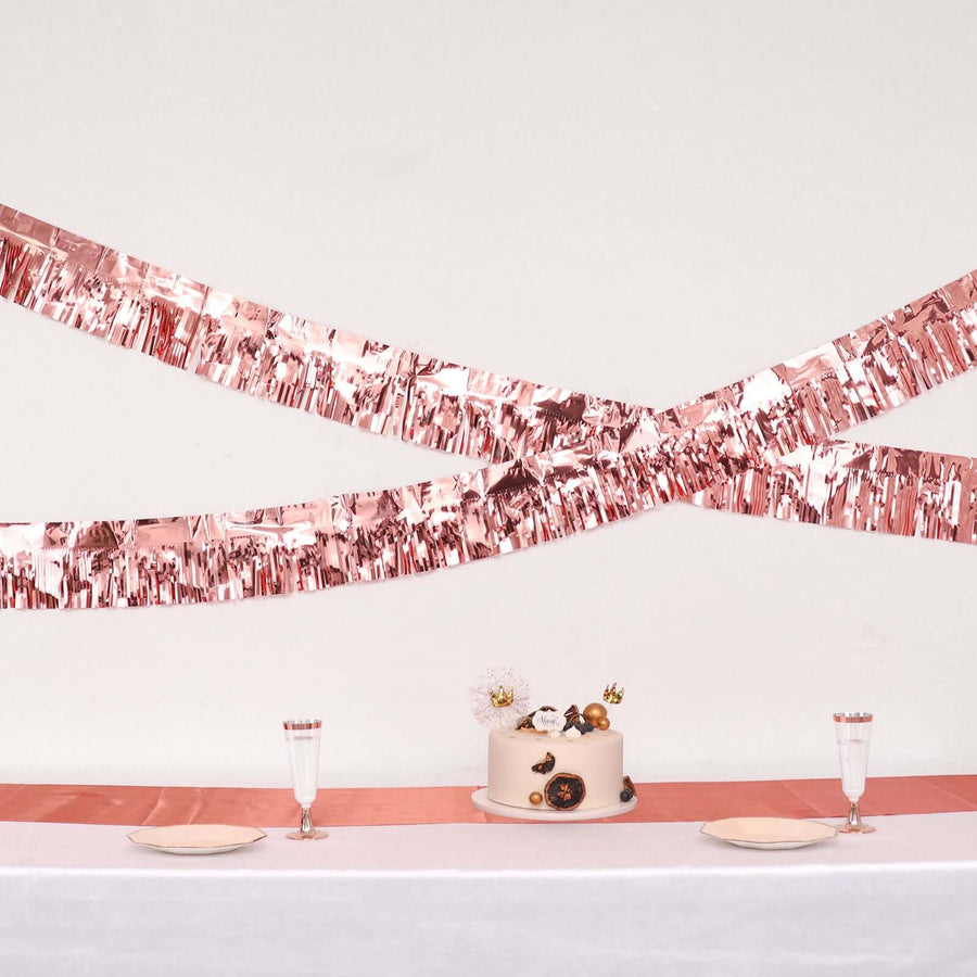 Rose gold party decorations with a cake and table setting.