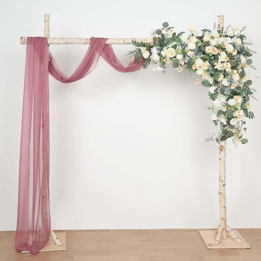 Wedding arch with floral arrangement and draped fabric.