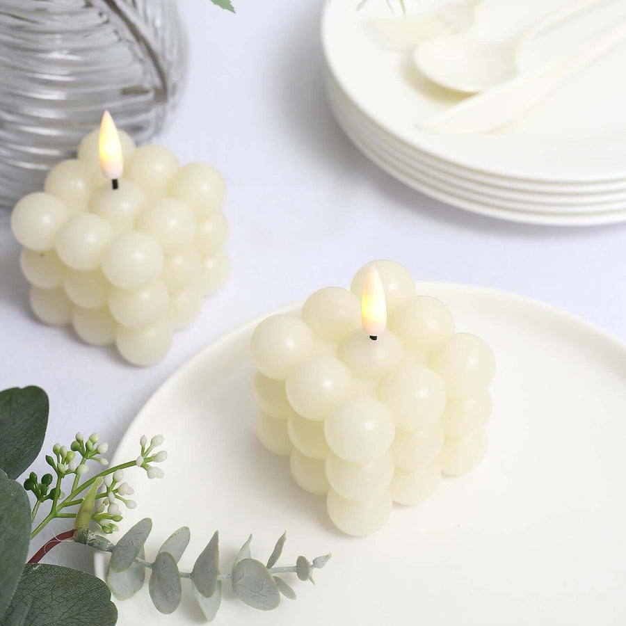 Decorative bubble candles on a table setting with plates and greenery.