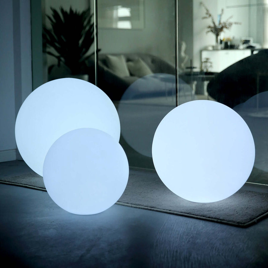 Glowing round decorative lights in varying sizes on a soft surface.
