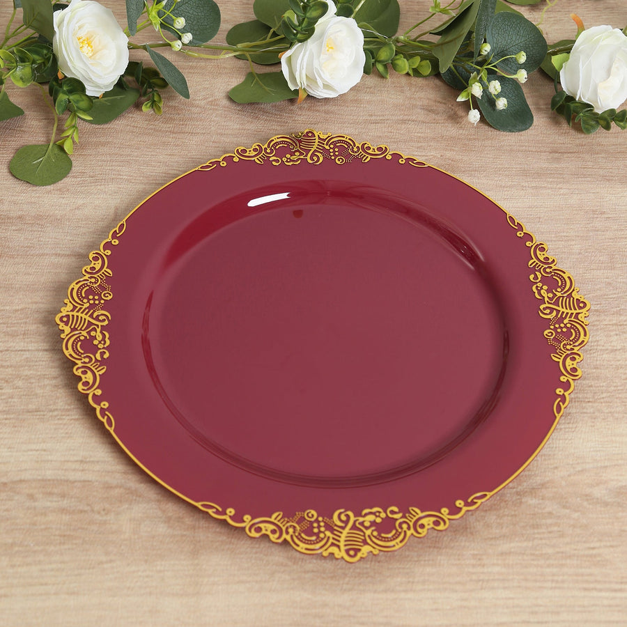 Burgundy decorative plate with gold detailing on a wooden surface.