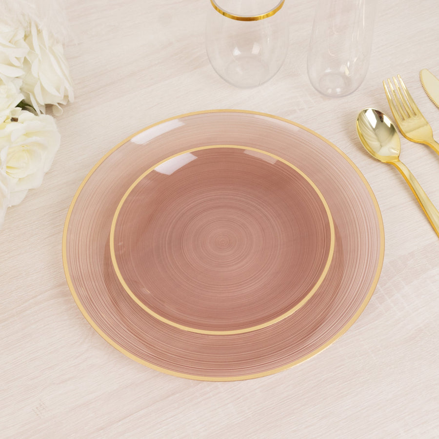 Elegant pink plate with gold rim on a light wooden table.