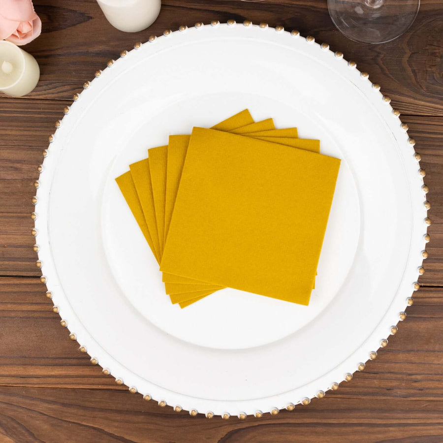 Yellow paper napkins stacked on a decorative plate.