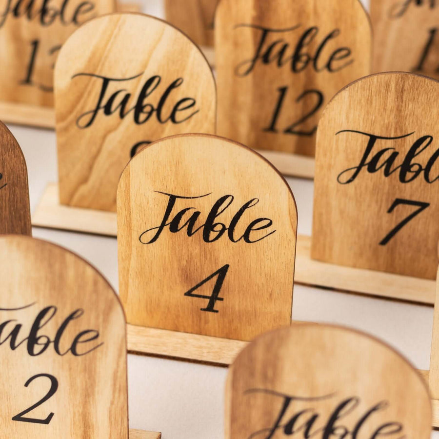 Wooden table number signs with elegant script, numbers 1 to 12.