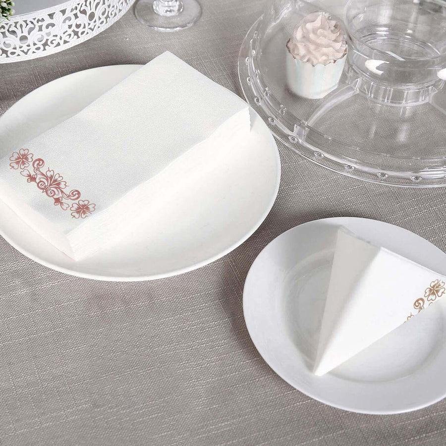 Elegant white napkins with floral design on a table setting.