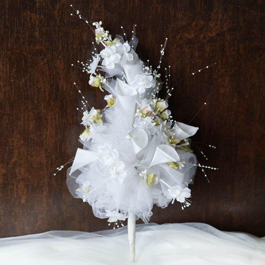 White floral arrangement with ribbons and tulle decor.