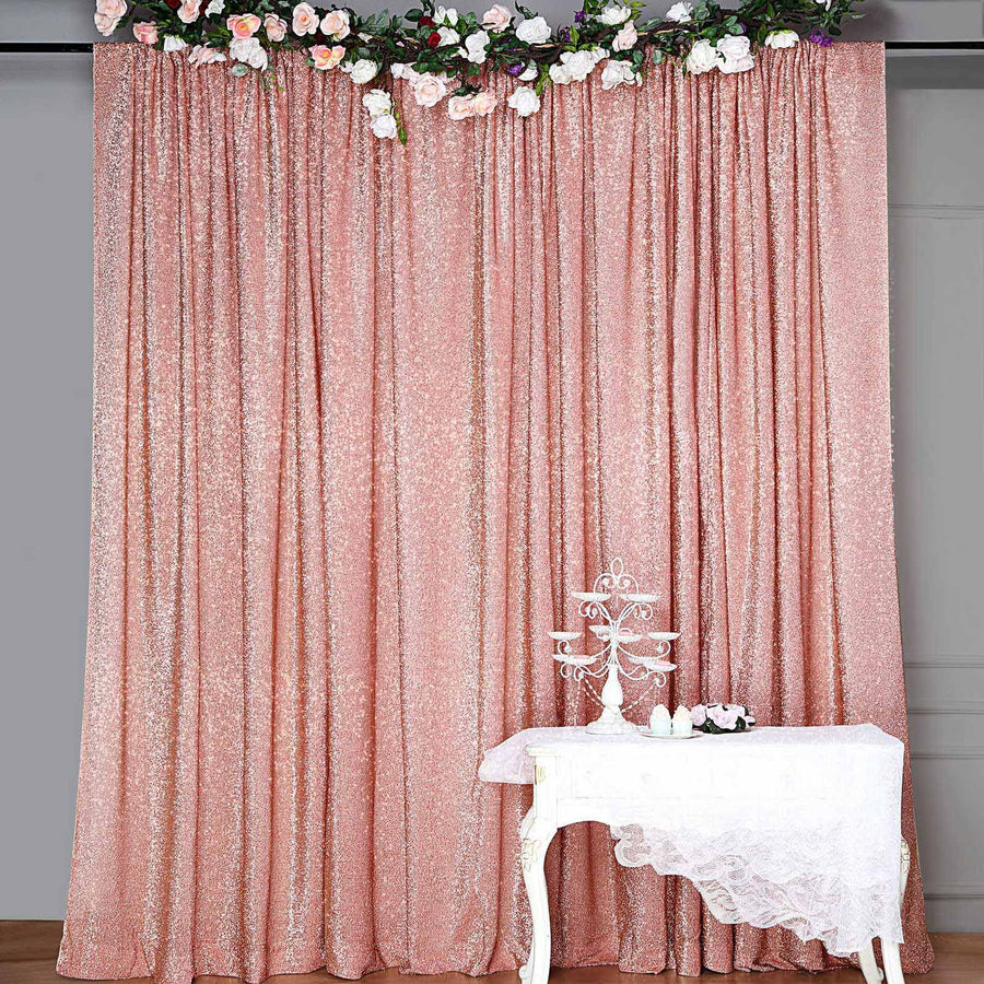 Rose gold sequin backdrop with floral accents and a white table.