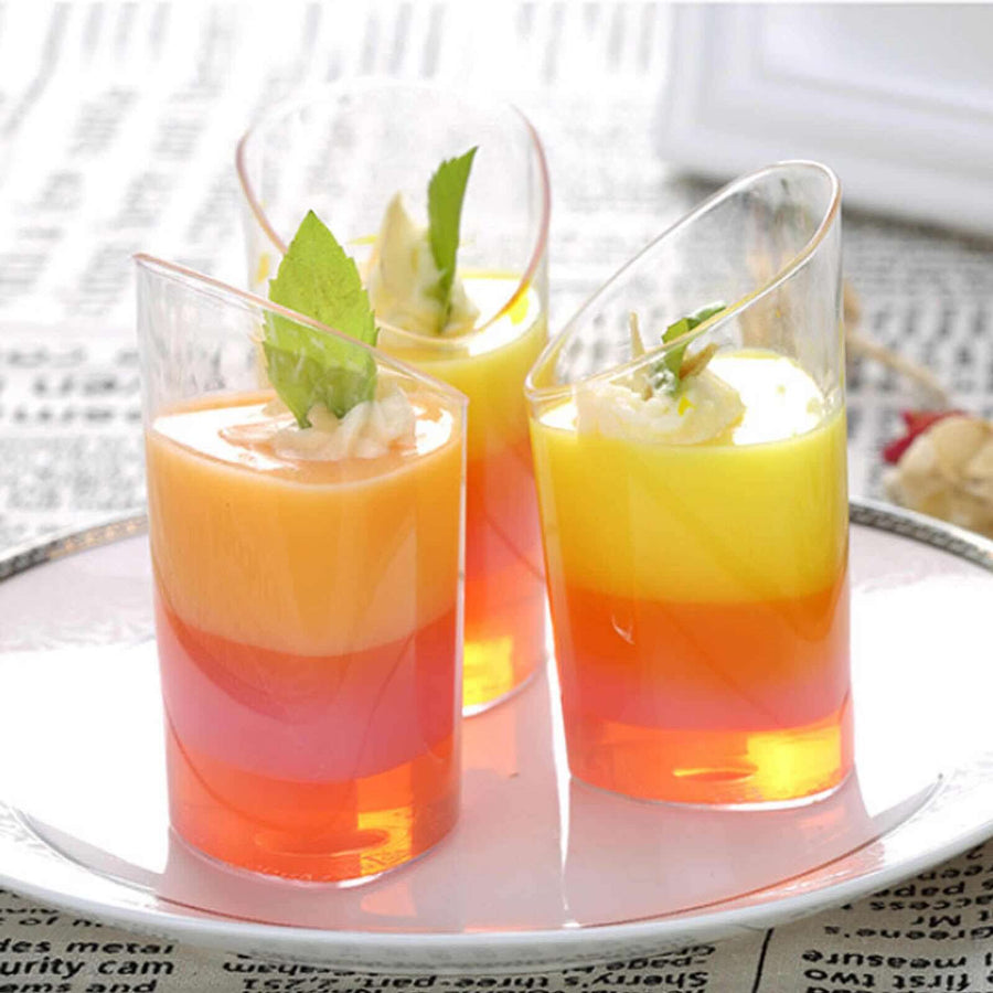 Colorful layered jelly desserts in clear cups, garnished with mint leaves.