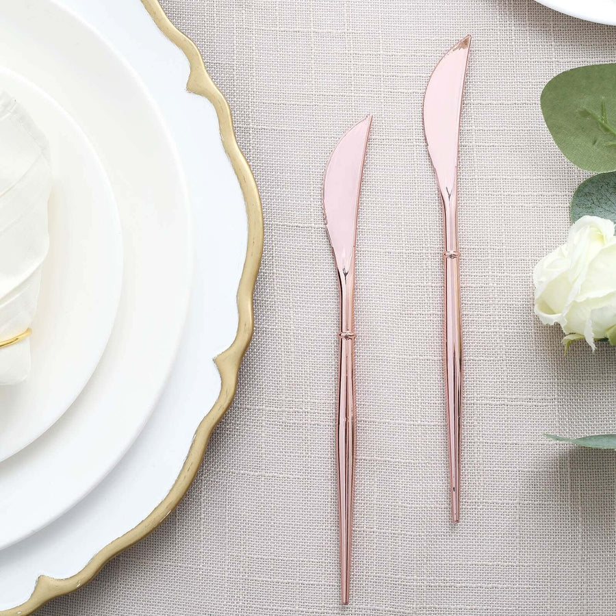 Rose gold butter knives on a textured tablecloth.