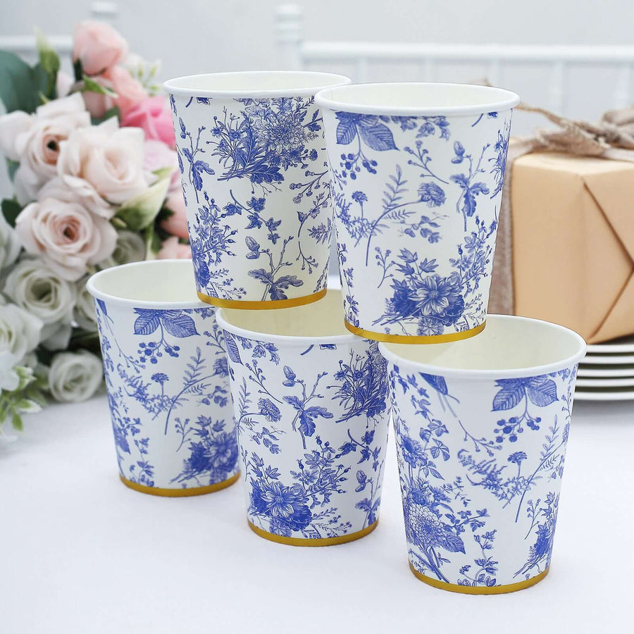 Blue floral disposable cups stacked elegantly on a table with flowers.