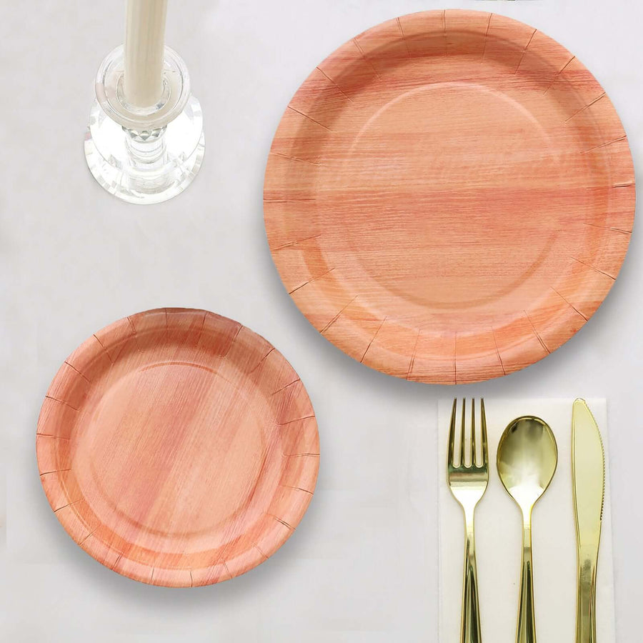 Set of wooden dinner and dessert plates with gold cutlery on a white background.