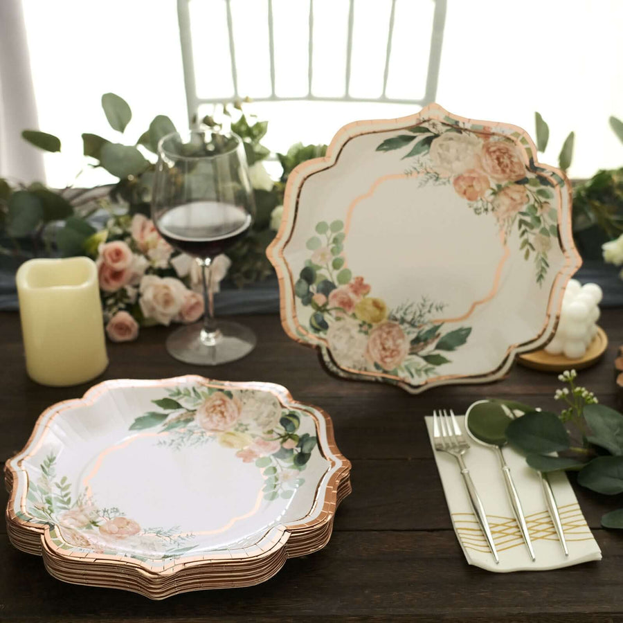 Floral decorative plates arranged on a table with wine and candles.