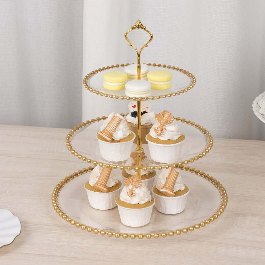 Three-tiered dessert stand with cupcakes and macarons on a wooden table.
